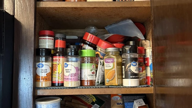 Messy spice cabinet with spice jars