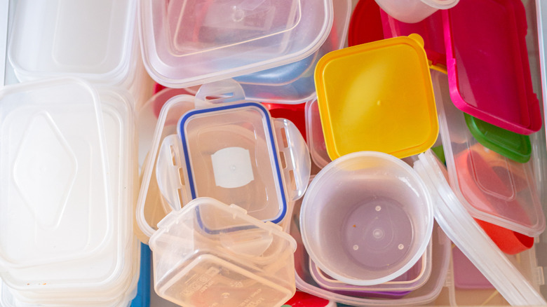 A kitchen drawer full of a large amount of plastic storage containers