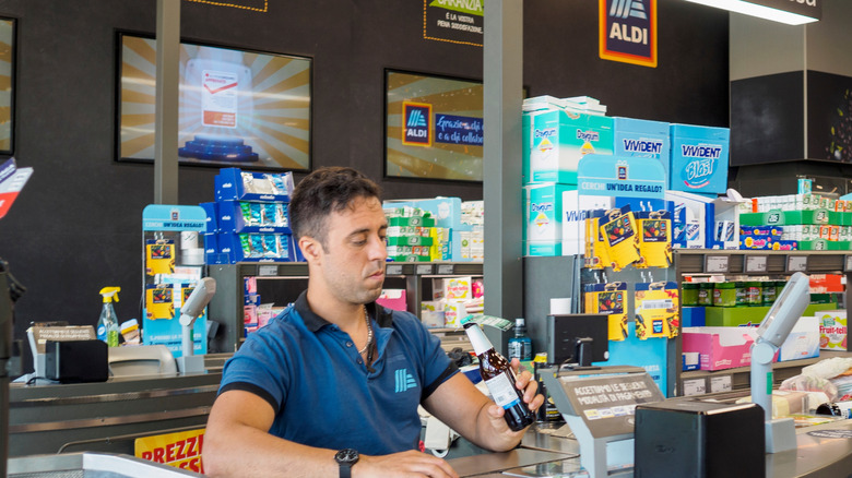 cashier scanning groceries at an ALDI checkout counter