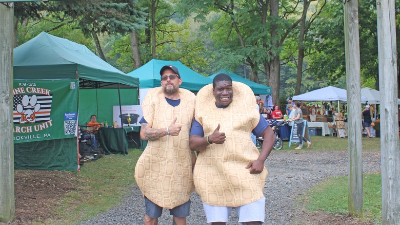 two men pose in peanut costumes at the peanut butter festival