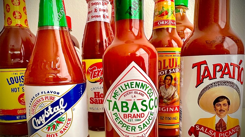 Bottles of hot sauce up close, with Crystal, Tabasco, and Tapatio prominently featured in front