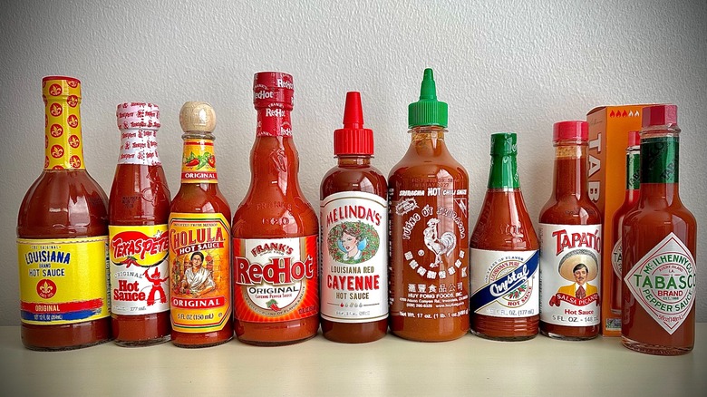 Bottles of (from left to right) Louisiana, Texas Pete, Cholula, Frank's Original, Melinda's Cayenne, Hoy Fung Siracha, Crystal, Tapatio, and Tabasco Red Pepper hot sauces