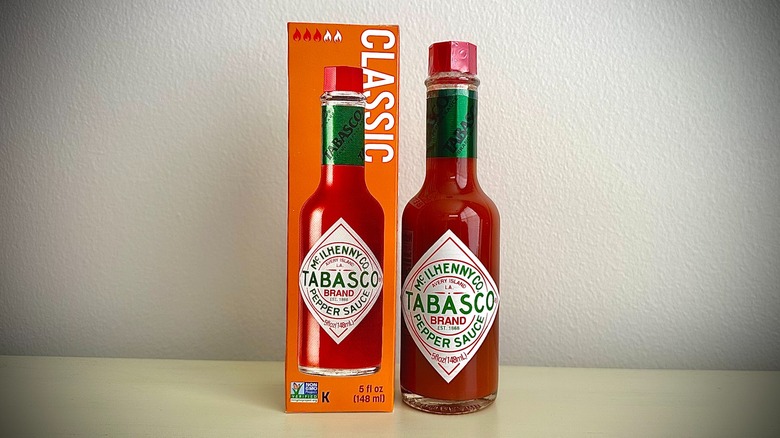 An unopened bottle of Tabasco Red Pepper sauce next to its box