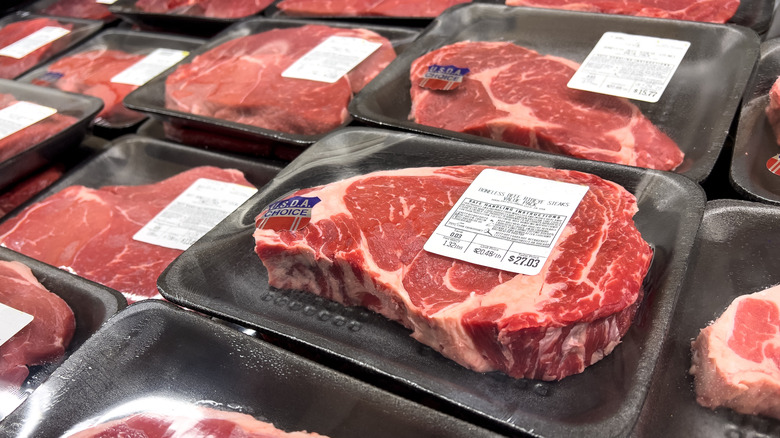 close up of steak in packaging stacked up in grocery store