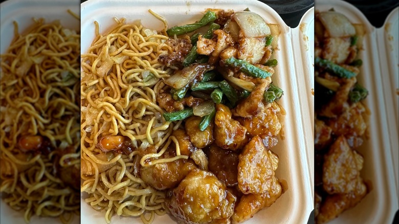 close up of chow mein and string bean chicken in takeout box, mirrored image