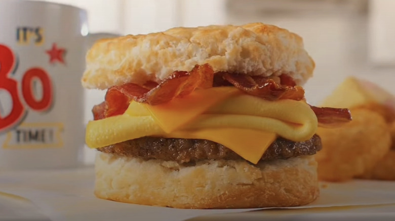 Hand holding Bojangles Triple Double Biscuit breakfast sandwich