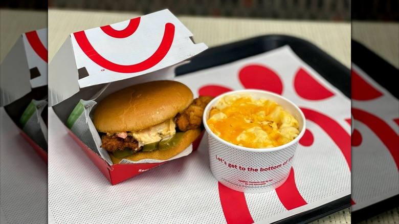 Chick-fil-A Honey Pepper Pimento Chicken Sandwich in cardboard box next to cup of mac and cheese on tray
