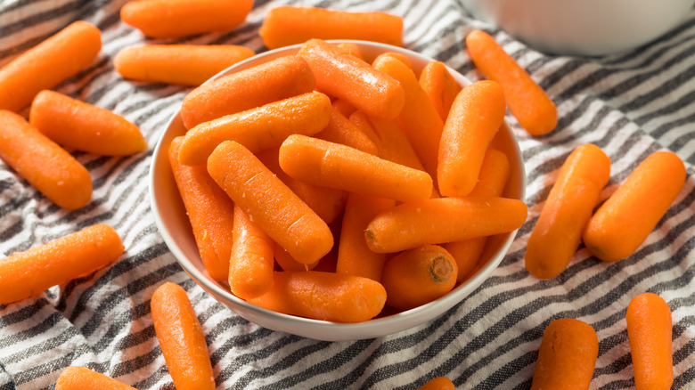 Organic Baby Carrots in a Bowl on striped tablecloth