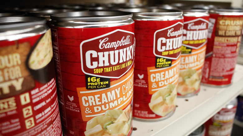 several cans of Campbell's chicken and dumplings soup on a shelf