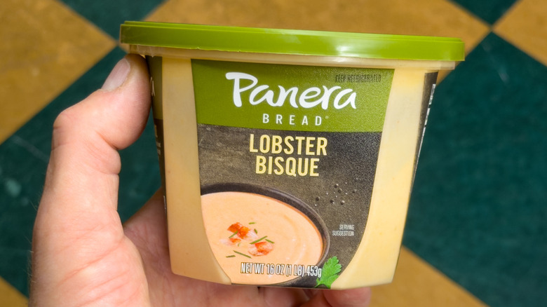 Hand holding container of Panera lobster bisque