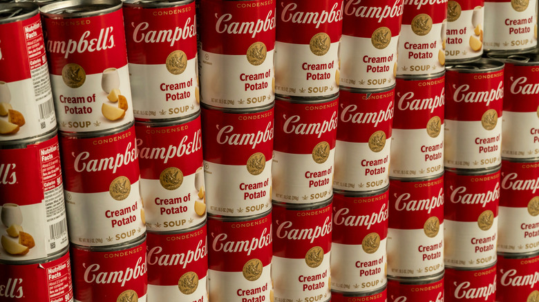 Several stacked cans of Campbell's cream of potato soup