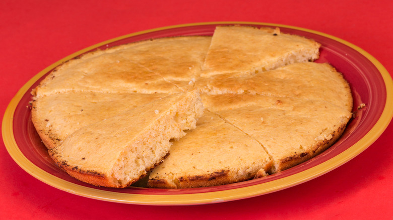 corn pone on a red plate against red background