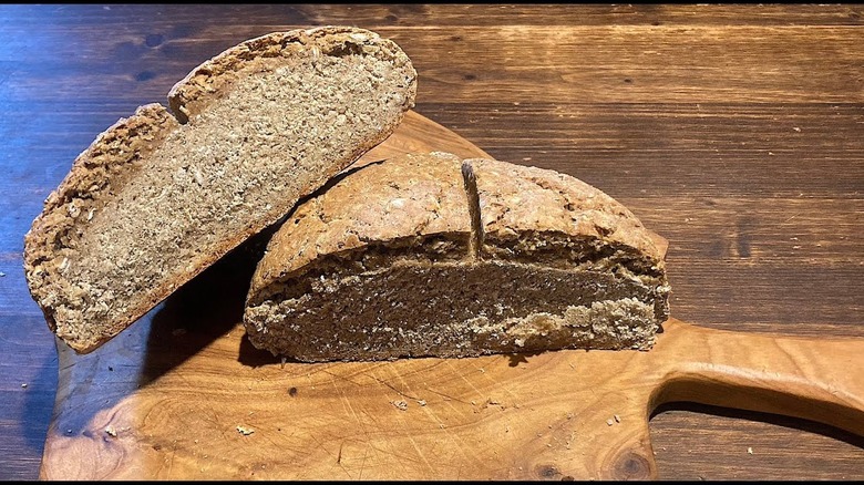 cut loaf of horse bread on wooden plank