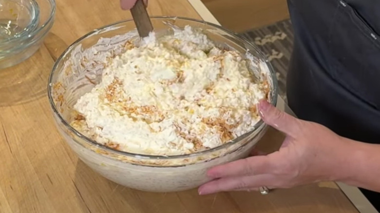 Frog eye salad being mixed in large bowl