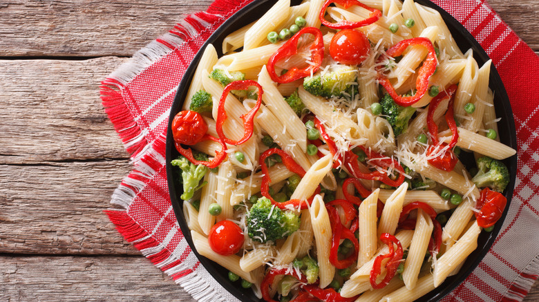 Pasta primavera in a bowl with tomatoes, broccoli, and peppers