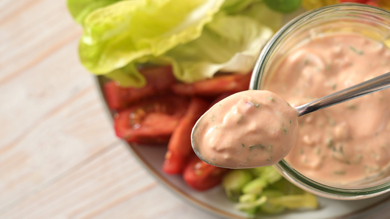 salad with thousand island dressing and spoon of dressing