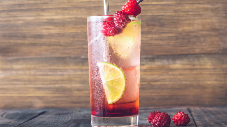 Raspberry lime rickey in a glass next to raspberries