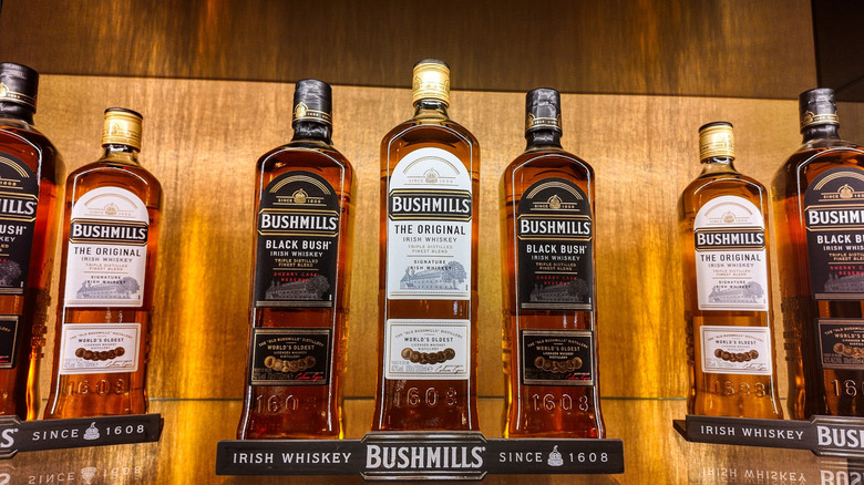 Bottles of Bushmills whiskey on a lit shelf