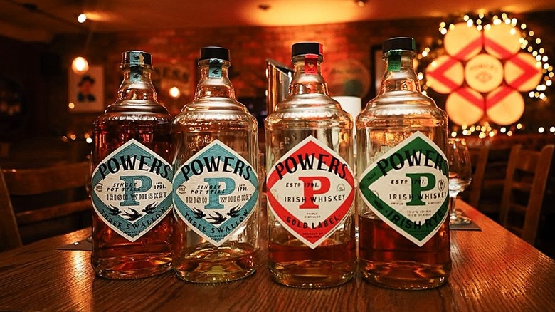 A row of Powers whiskey bottles