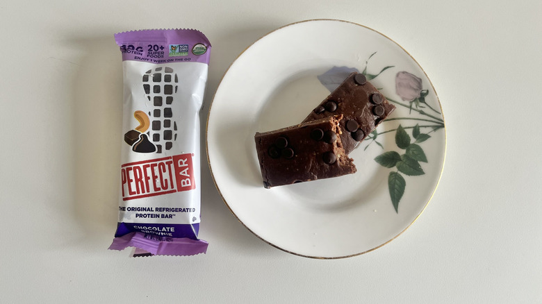 Chocolate Brownie Perfect Bar on a plate next to the wrapper