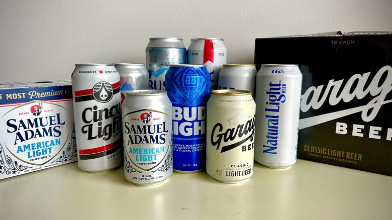 Nine bottles of light beer, as well as a box of Garage Beer and Samuel Adams American Light positioned on either side