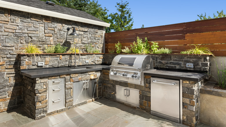 Outdoor kitchen with grill and plants