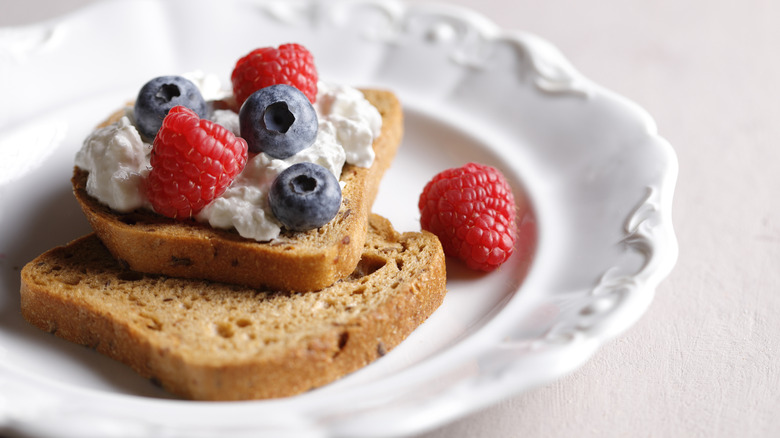 Slices of toast on plate, topped with cottage cheese and berries