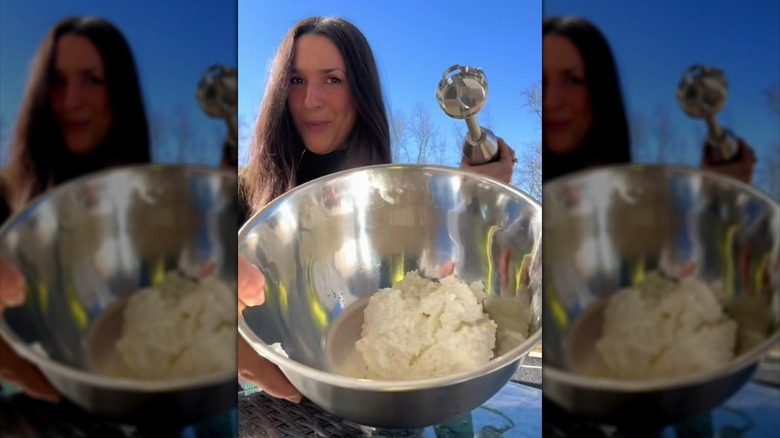 Person holding metal mixing bowl filled with cottage cheese