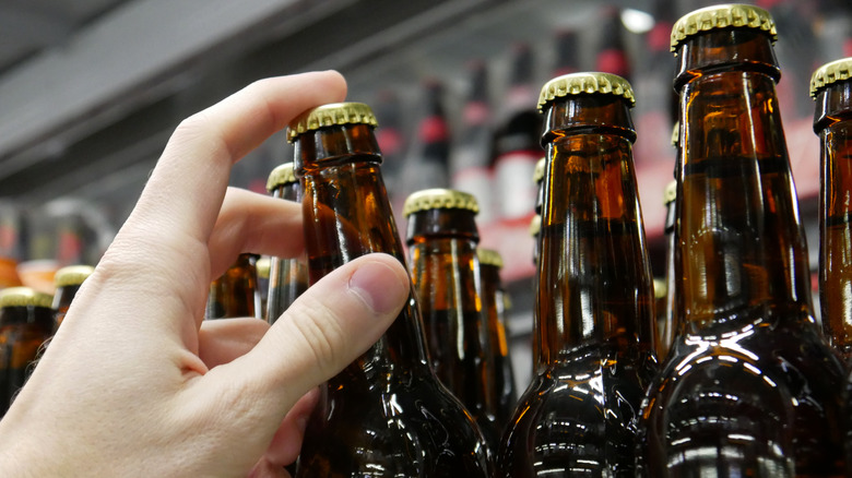 Hand reaching for a bottle of beer