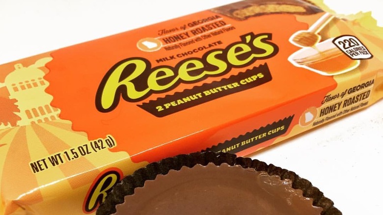 Unopened Reese's Georgia Honey-Roasted Peanut Butter cups wrapper next to one candy cup