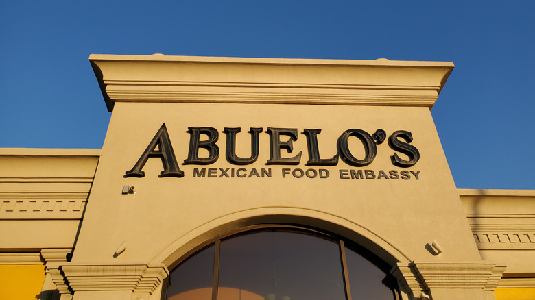 Sign for ABUELO'S MEXICAN FOOD EMBASSY on yellow building beneath Blue Sky