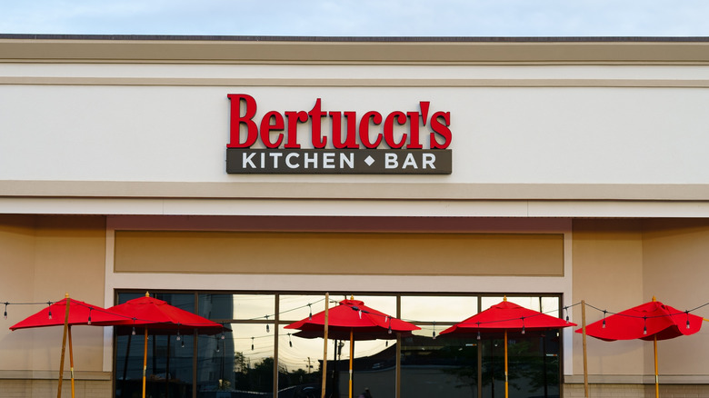Bertucci's Kitchen and Bar sign outside restaurant above red umbrellas