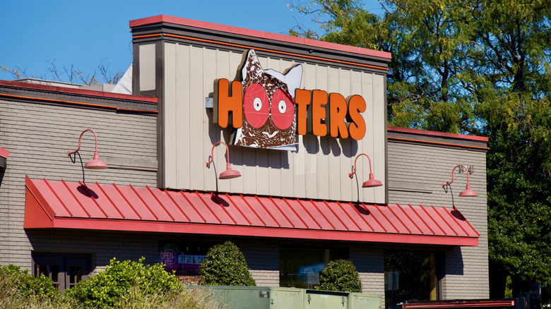 outside of Hooters restaurant with large sign complete with owl logo