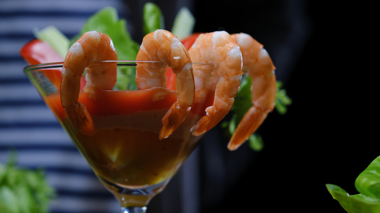 Shrimp cocktail served in martini glass with sauce and greenery