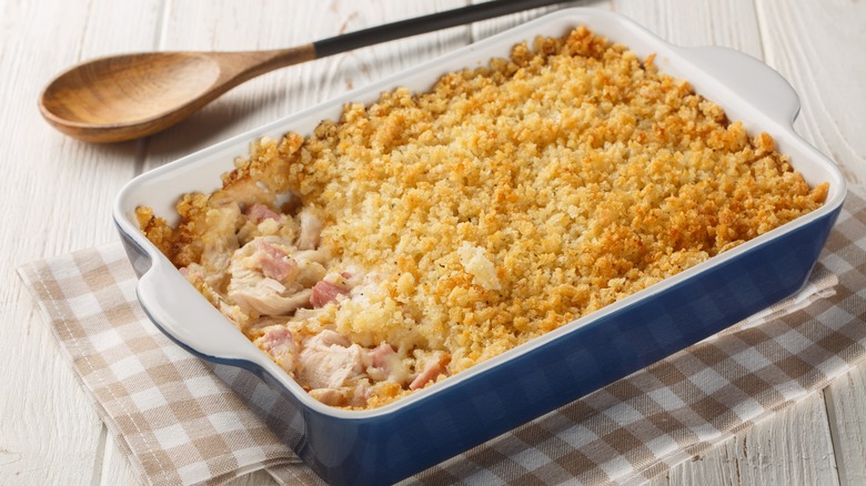 Chicken casserole in baking pan on checkered cloth towel.