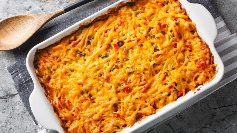 King Ranch chicken casserole in white baking dish on cloth towel.