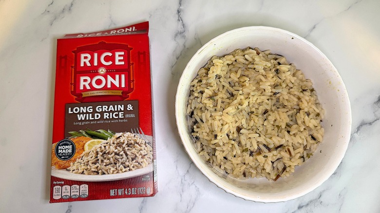 Top-down shot of bowl of Long Grain & Wild Rice Rice-A-Roni next to box on marble surface