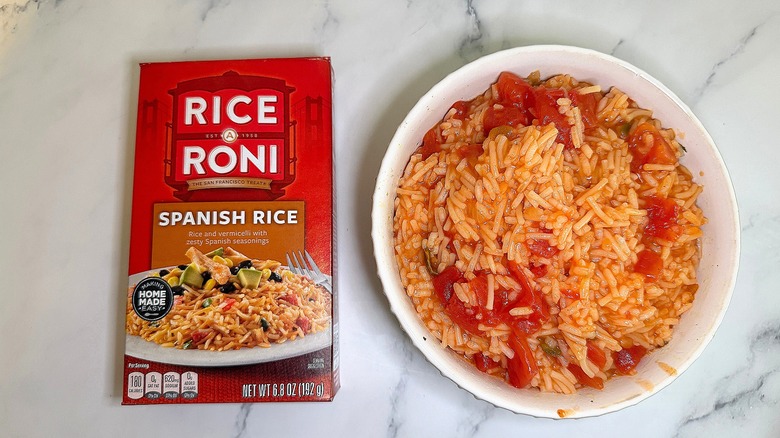 Top-down shot of bowl of Spanish Rice Rice-A-Roni next to box on marble surface