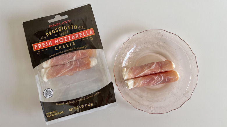 Prosciutto wrapped mozzarella cheese pieces on a plate