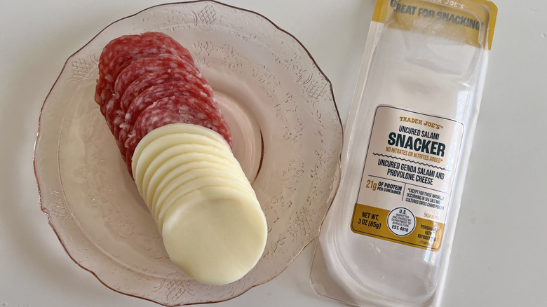Open plastic container of salami snacks with cheese