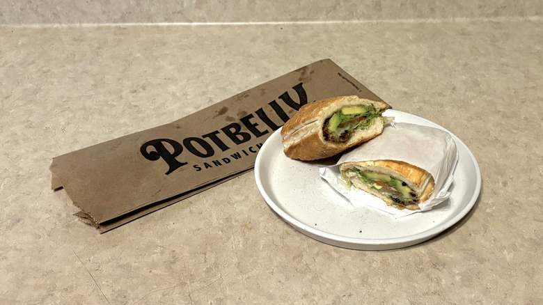 Potbelly BLTA sandwich on white plate and neutral counter.