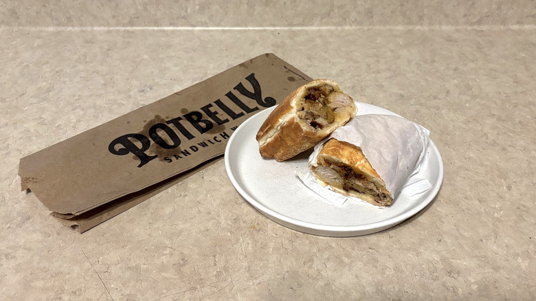 Potbelly sweet heat pork bbq sandwich on white plate and neutral counter.