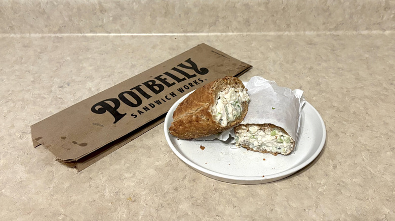 Potbelly chicken salad sandwich on white plate and neutral background.