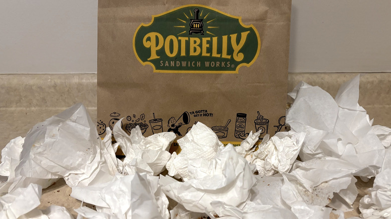 Potbelly sandwich bag with paper wrappers on neutral background.