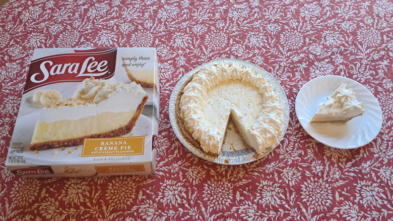 whole pie in tin next to single slice and packaging on table