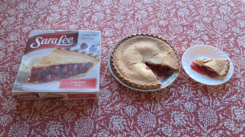 whole pie in tin next to single slice and packaging on table