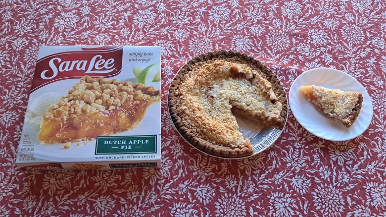 whole pie in tin next to single slice and packaging on table
