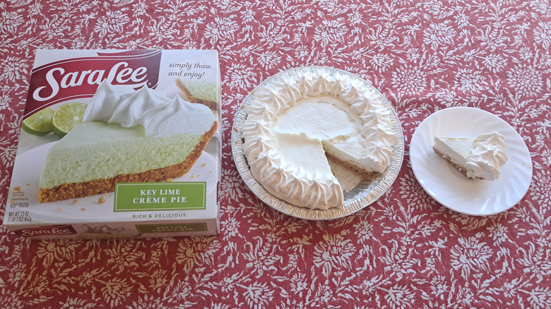 whole pie in tin next to single slice and packaging on table
