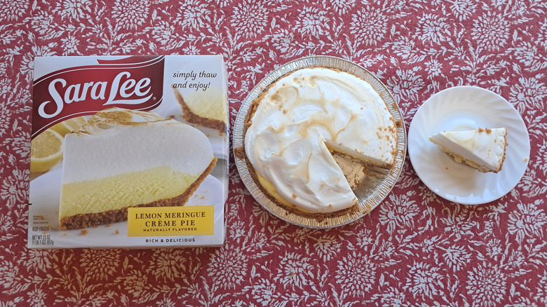 whole pie in tin next to single slice and packaging on table