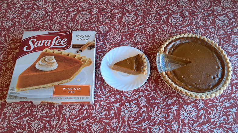 whole pie in tin next to single slice and packaging on table